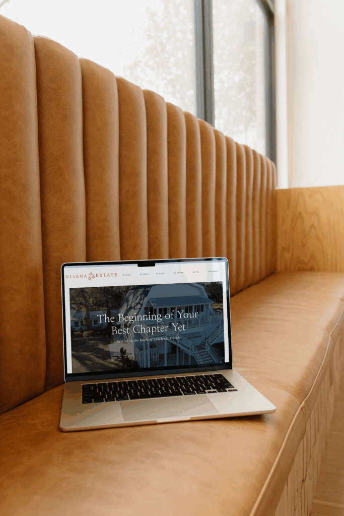 Laptop on brown couch with a website on the screen for uliana estate